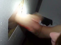 Sexy brunette works a cock through the glory hole