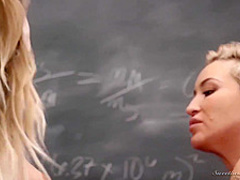 Short haired blonde is about to make love with a woman in an empty classroom